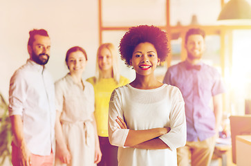 Image showing happy young woman over creative team in office