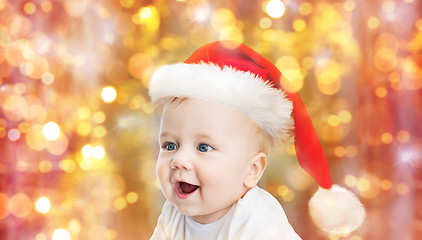 Image showing baby boy in christmas santa hat over blue lights