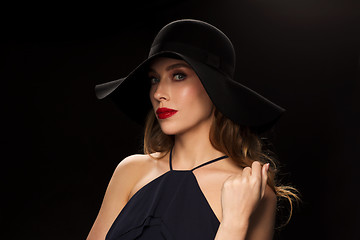 Image showing beautiful woman in black hat over dark background