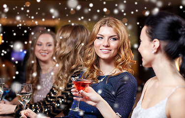 Image showing happy women with drinks at night club over snow
