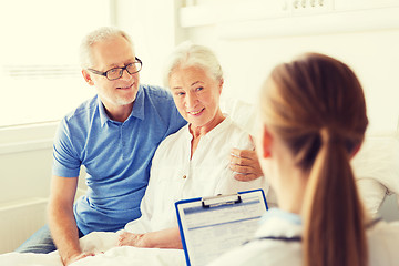 Image showing senior woman and doctor with clipboard at hospital