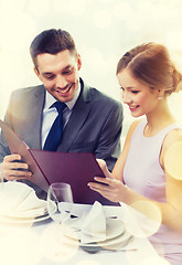 Image showing smiling couple with menu at restaurant