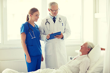 Image showing doctor and nurse visiting senior woman at hospital