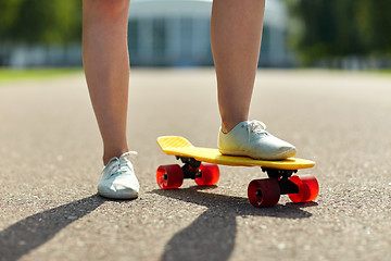 Image showing close up of female feet riding short skateboard