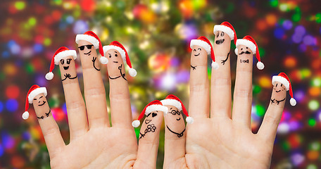 Image showing close up of fingers with smiley in santa hats