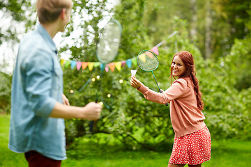 Image showing happy friends playing badminton at summer garden