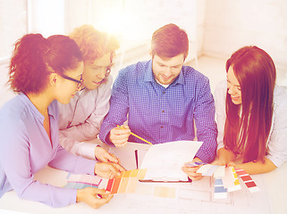 Image showing team with color samples and blueprint at office