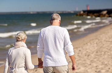 Image showing senior couple walking along summer beach