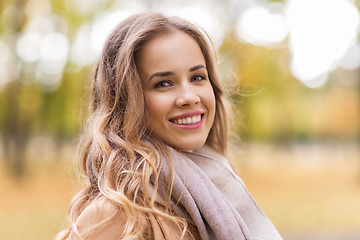 Image showing beautiful happy young woman smiling in autumn park