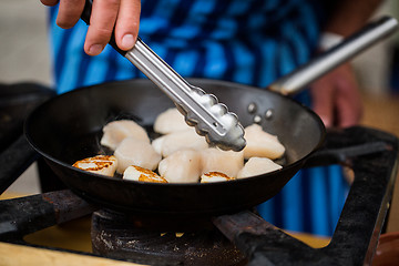 Image showing close up of scallops frying in cast iron pan