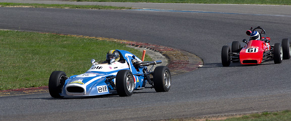 Image showing Two old race cars turning