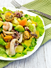 Image showing Salad with seafood and avocado in plate on  light board