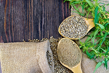 Image showing Flour hemp with grain in wooden spoons on board