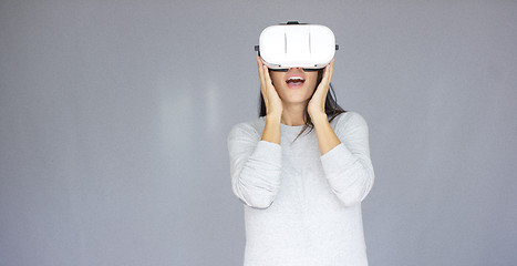 Image showing Excited woman watching something on her virtual reality helmet