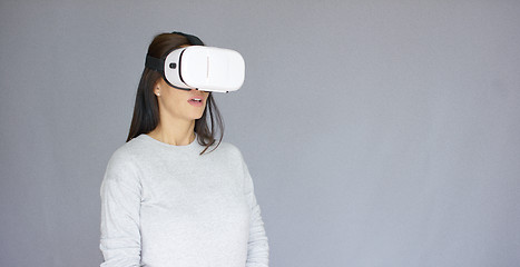 Image showing Excited woman watching something on her virtual reality helmet