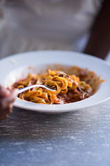 Image showing a young African American woman eating pasta