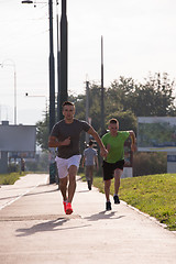 Image showing Two young men jogging through the city