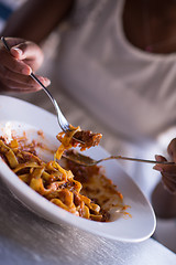 Image showing a young African American woman eating pasta