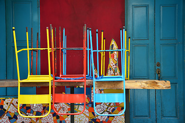 Image showing Colorful chairs on a wooden table