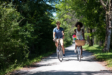 Image showing Young multiethnic couple having a bike ride in nature