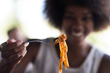 Image showing a young African American woman eating pasta