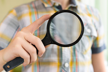 Image showing Brainy lad with magnifying glass