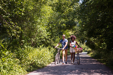 Image showing Young multiethnic couple having a bike ride in nature