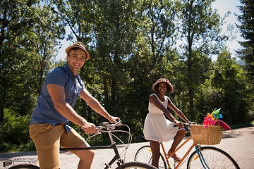 Image showing Young multiethnic couple having a bike ride in nature