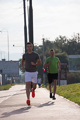 Image showing Two young men jogging through the city