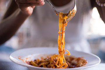 Image showing a young African American woman eating pasta