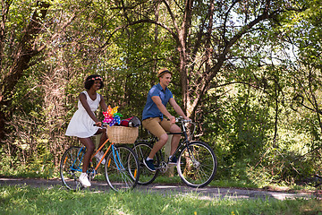 Image showing Young multiethnic couple having a bike ride in nature