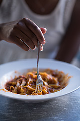 Image showing a young African American woman eating pasta