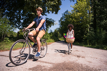 Image showing Young multiethnic couple having a bike ride in nature