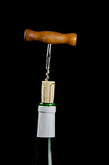 Image showing Uncorking a wine bottle with a vintage corkscrew