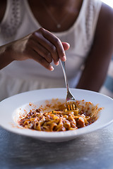 Image showing a young African American woman eating pasta