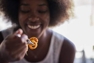 Image showing a young African American woman eating pasta