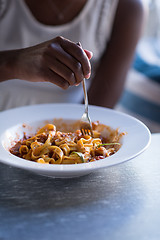 Image showing a young African American woman eating pasta