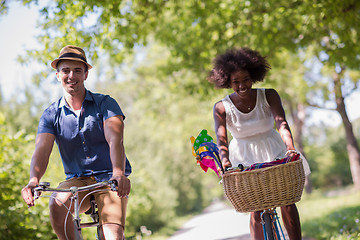 Image showing Young multiethnic couple having a bike ride in nature