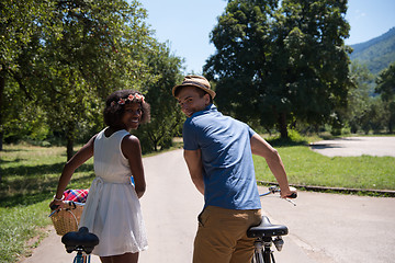 Image showing Young multiethnic couple having a bike ride in nature