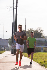 Image showing Two young men jogging through the city