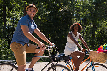 Image showing Young multiethnic couple having a bike ride in nature