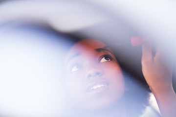 Image showing a young African-American woman makeup in the car