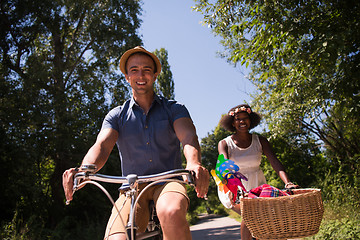 Image showing Young multiethnic couple having a bike ride in nature