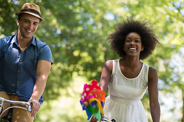 Image showing Young multiethnic couple having a bike ride in nature