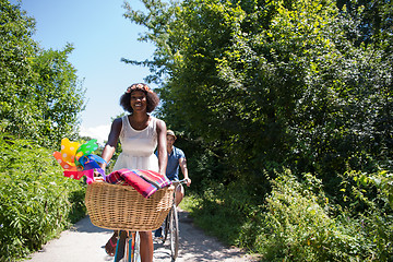 Image showing Young multiethnic couple having a bike ride in nature