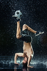 Image showing Water drops around football player