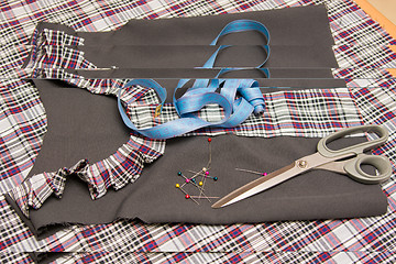 Image showing Top view of the child billet school dress lying on the table with sewing accessories