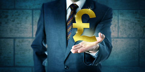 Image showing Trader Holding A Golden British Pound Sterling Symbol