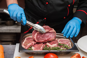 Image showing Chef cutting meat