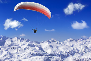 Image showing Paragliding over the mountains on background of blue sky and whi